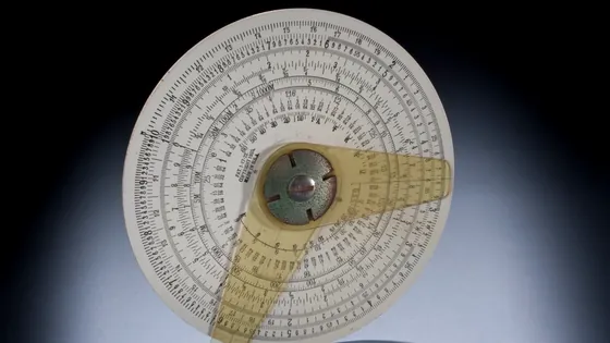 A circular slide rule photographed against a dark background