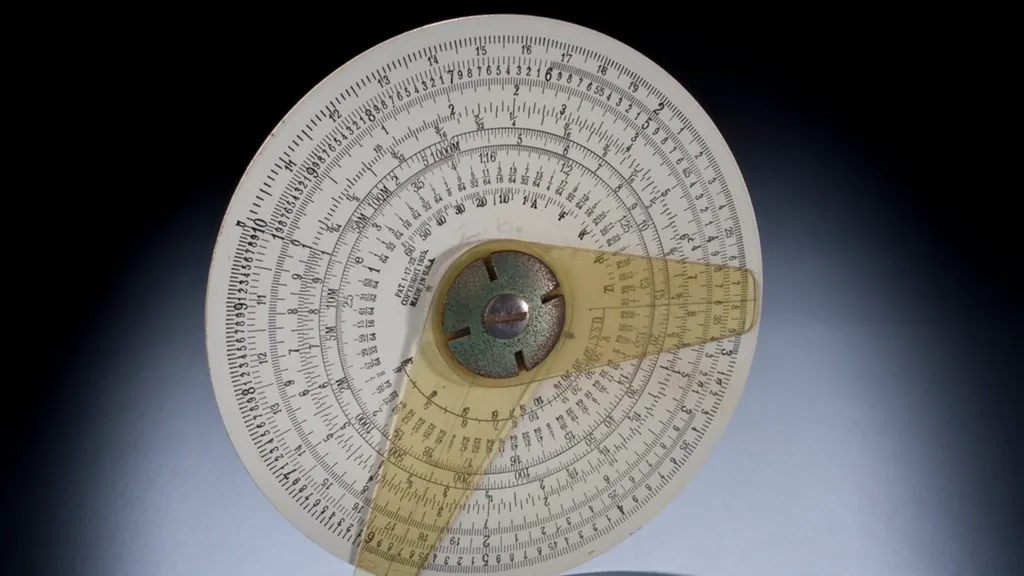 A circular slide rule photographed against a dark background